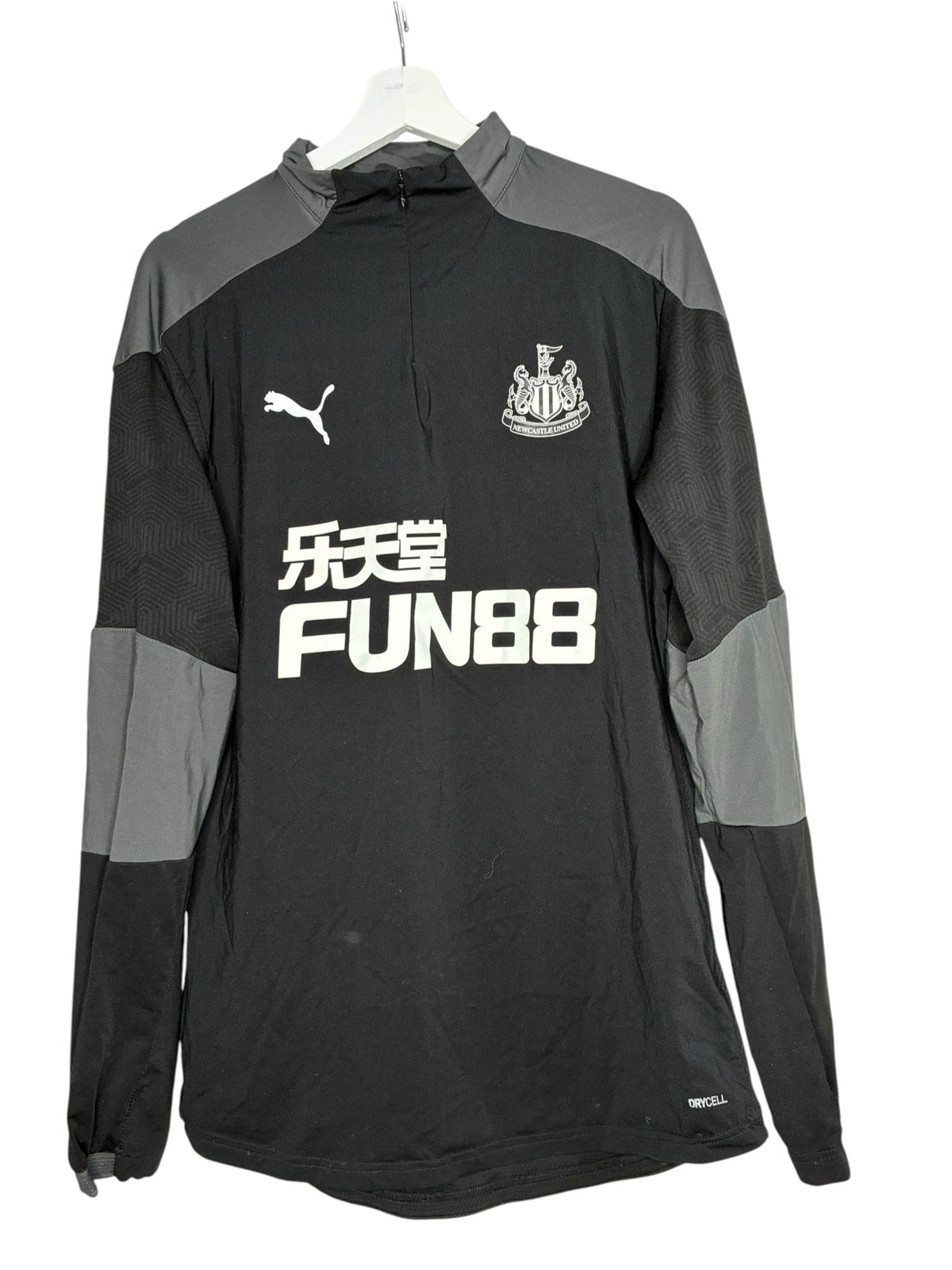Haut d'entraînement Puma Newcastle United noir et gris avec logo du club, vendu par Levestiairedupeuple