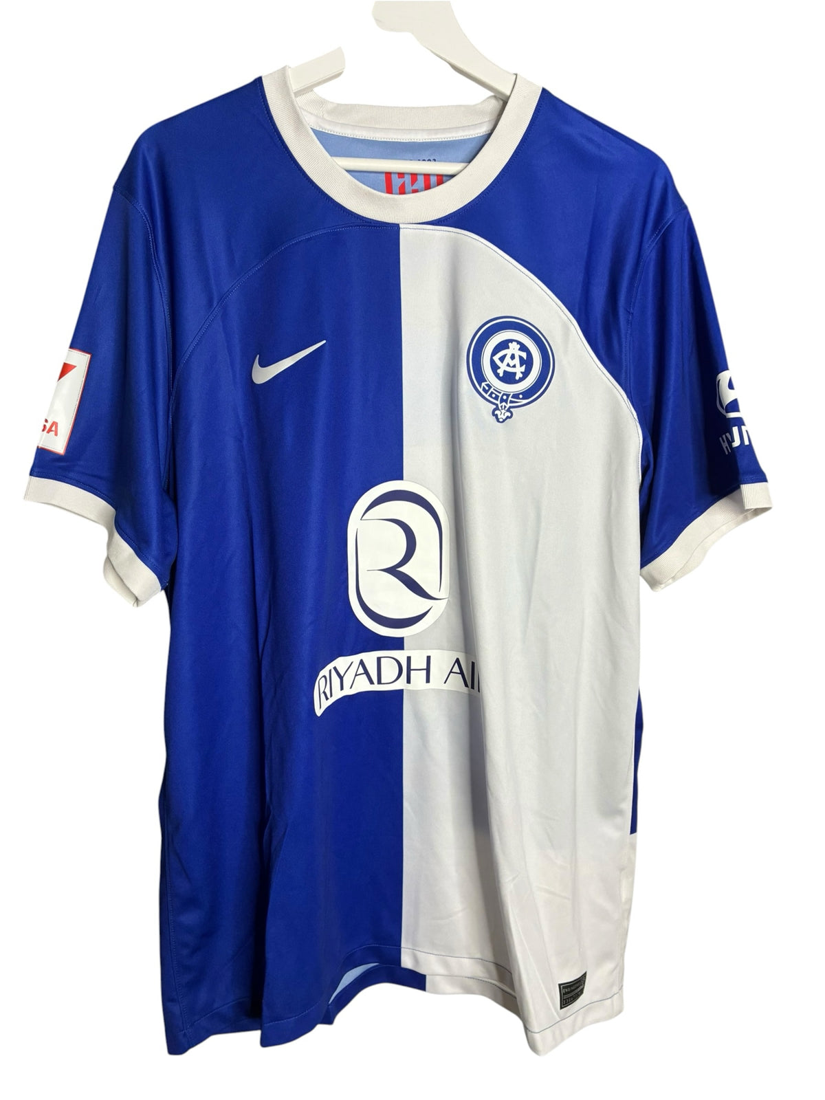 Maillot de football officiel Levestiairedupeuple de l'Atletico de Madrid, design bicolore bleu et blanc.